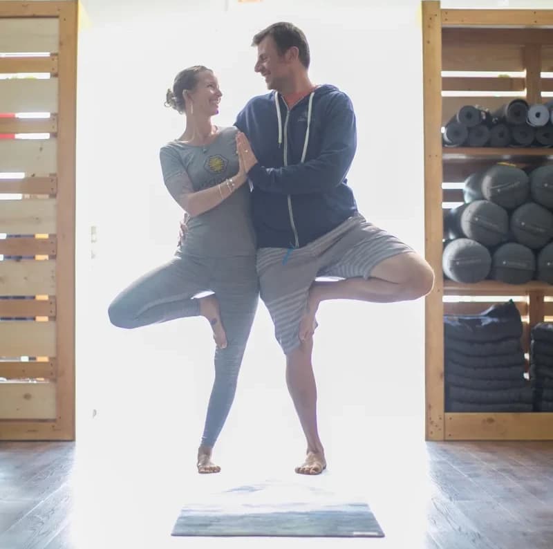 kevin and jenn practicing tree pose together in the yoga hive studio